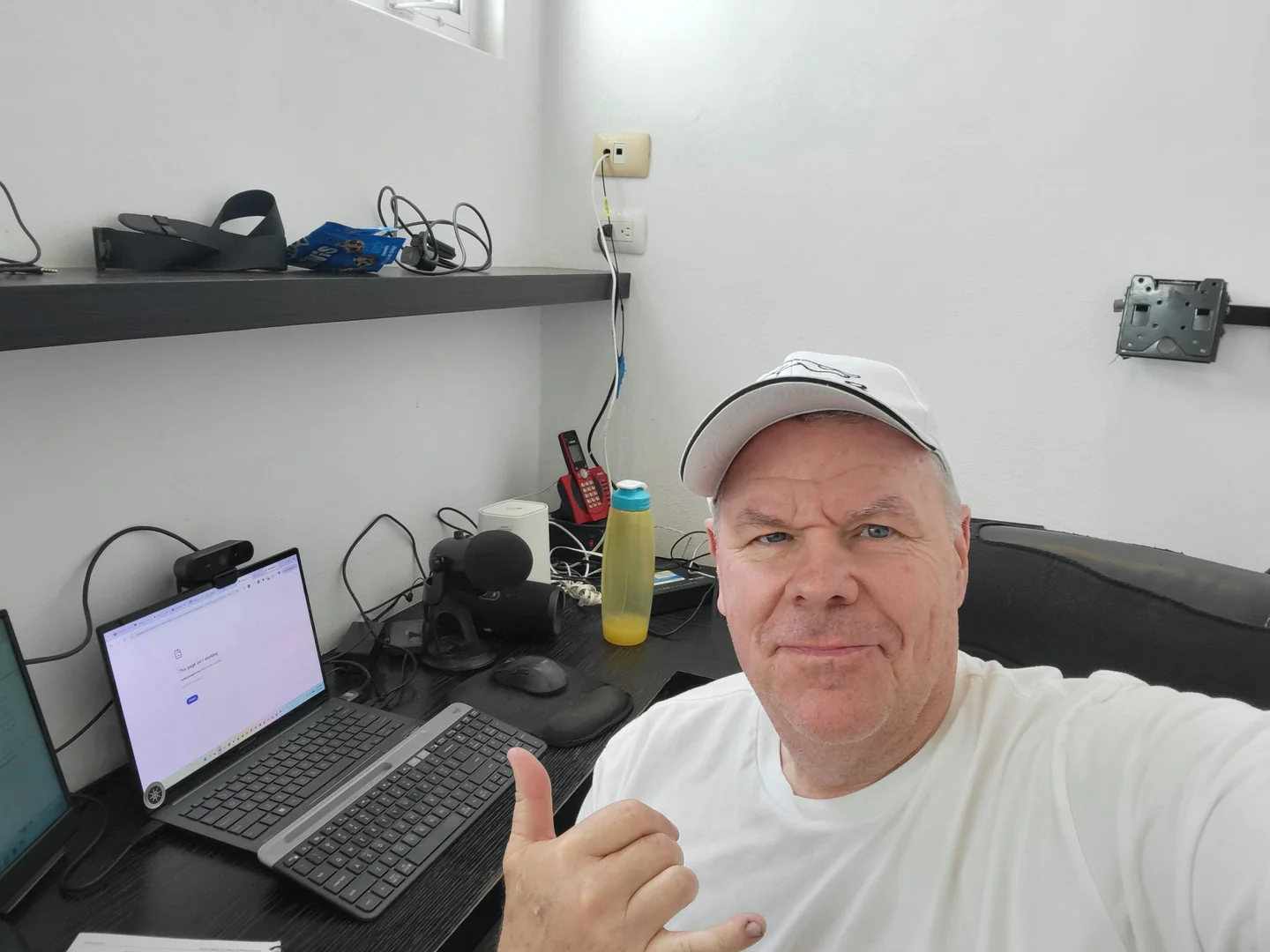 Derk in his real home office in Cozumel, seated beside the computers and networking equipment he depends on for work